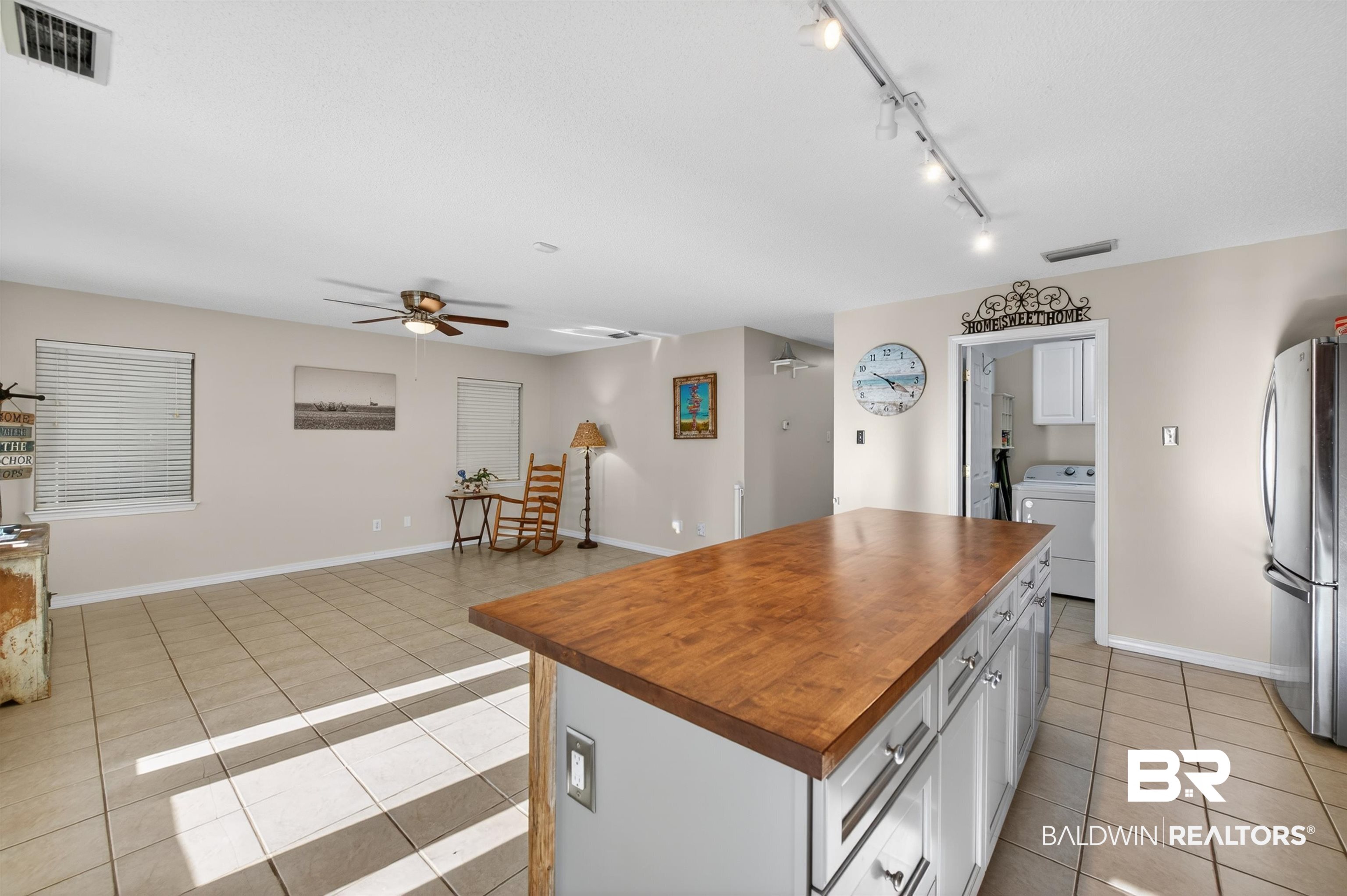 9624 North Bay Street Foley, AL 36535 - Photo 13 of 59 Kitchen island with wood-finish countertop and light-colored cabinetry featuring contemporary hardware