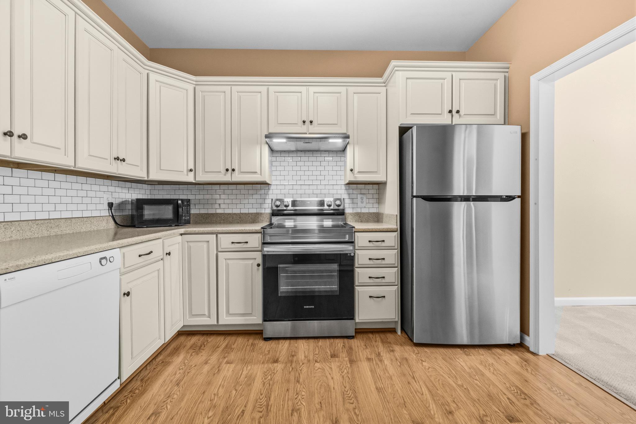 2116 Green Watch Way, Unit 200D Reston, VA 20191 - Photo 15 of 38 a kitchen with a refrigerator stove and white cabinets