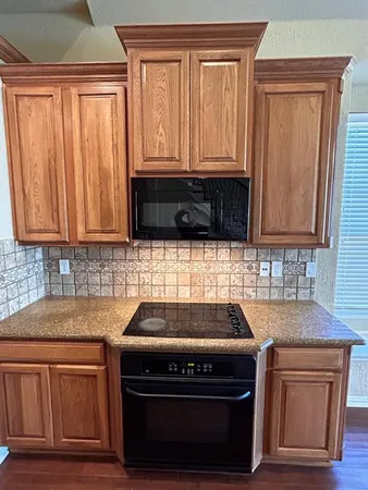 a kitchen with granite countertop cabinets stove and oven