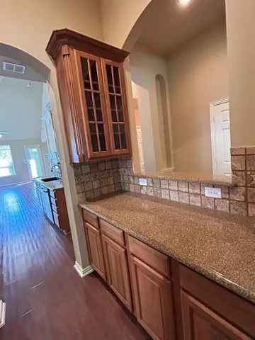 a kitchen with granite countertop a sink window and cabinets