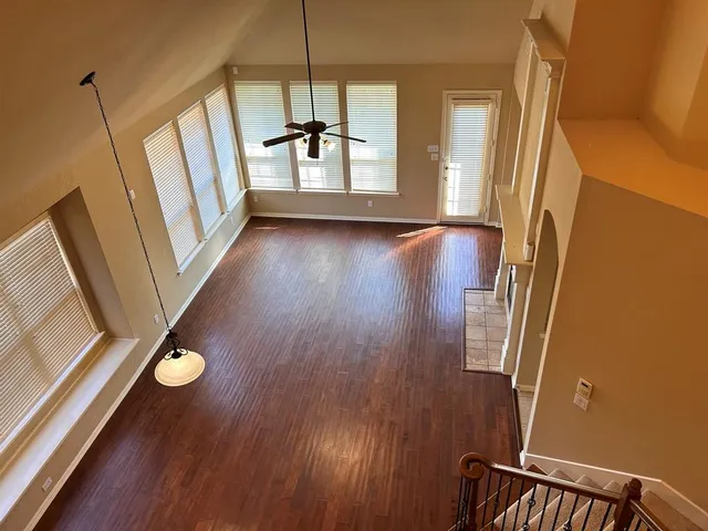 a living room with a bed and a table with wooden floor