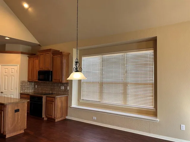 a kitchen with a sink a microwave and cabinets