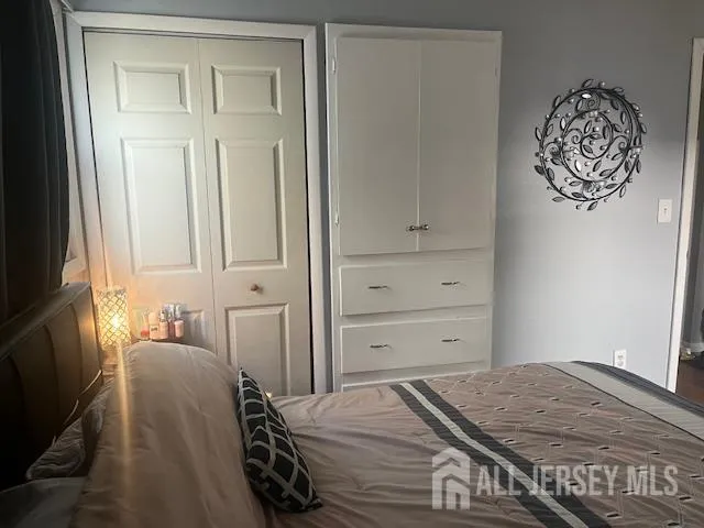 a bedroom with a bed and a painting on the wall