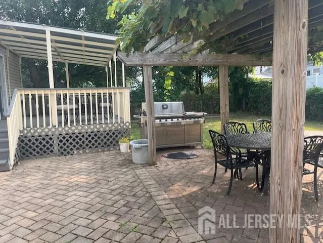 a roof deck with table and chairs and wooden floor