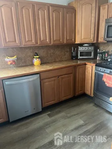 a kitchen with granite countertop a sink a stove and cabinets