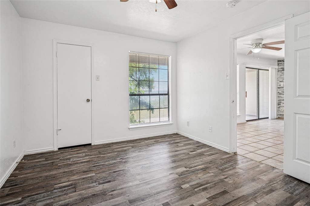 4472 Chaha Road, Unit 103 Garland, TX 75043 - Photo 10 of 16 a view of an empty room with wooden floor and a window