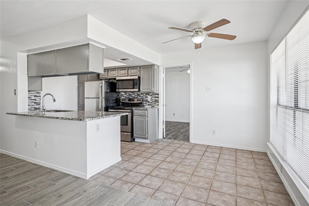 4472 Chaha Road, Unit 103 Garland, TX 75043 - Photo 16 of 16 a kitchen with kitchen island a stove a sink and a refrigerator