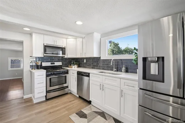 a kitchen with granite countertop a refrigerator stove and microwave