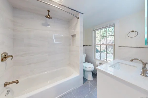 a white bath tub sitting next to a white sink and a toilet