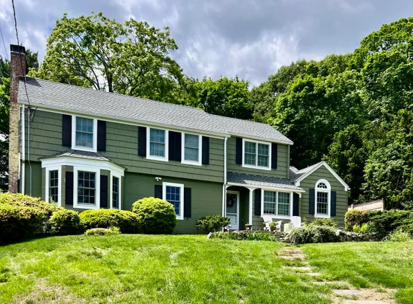 a front view of a house with a yard and trees