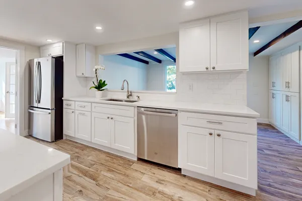 a kitchen with white cabinets stainless steel appliances and a refrigerator