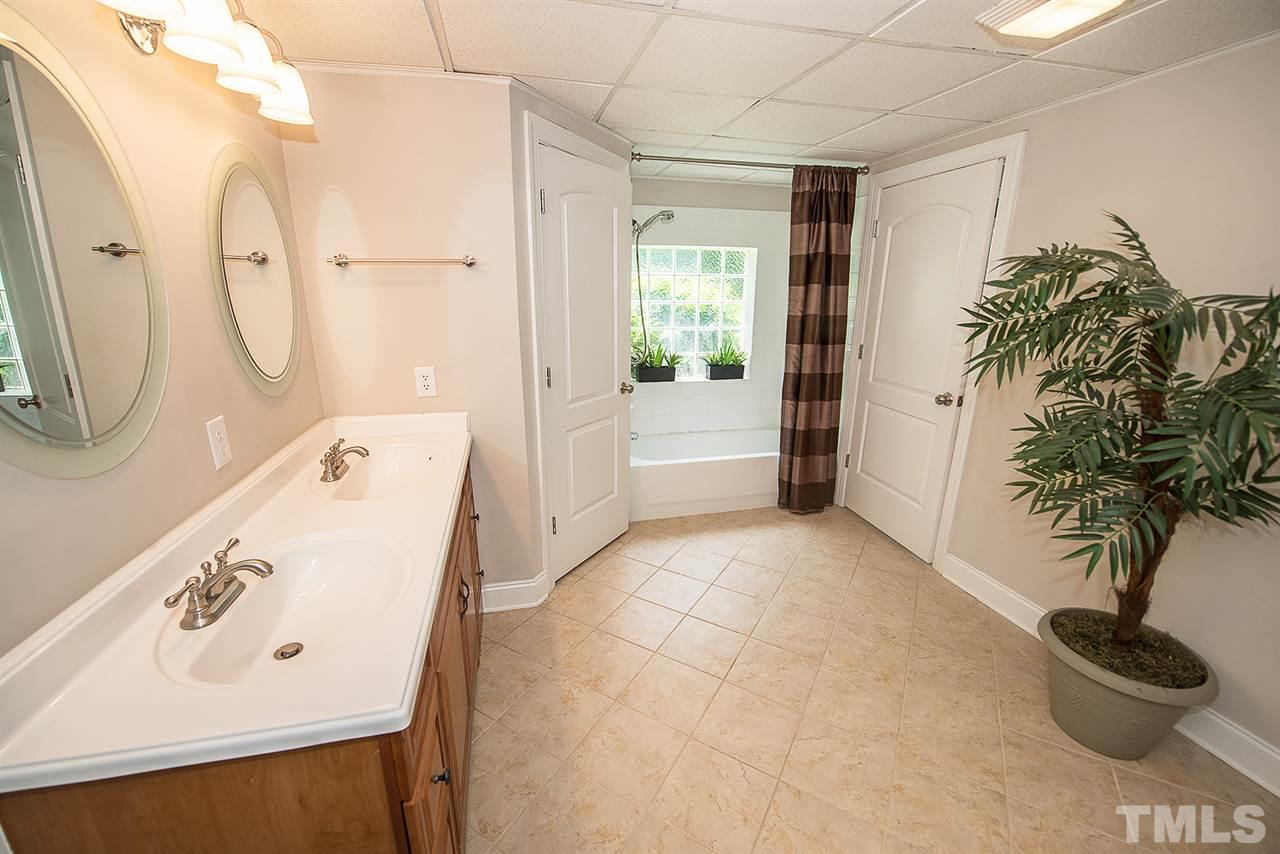 6820 Lake Wheeler Road Raleigh, NC 27603 - Photo 15 of 25 Full bathroom off of the basement bonus room has dual sink marble vanity and tile flooring.