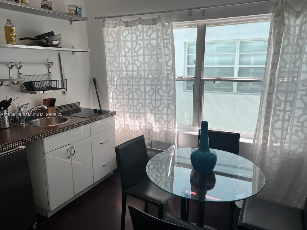 1555 Pennsylvania Avenue, Unit 107 Miami Beach, FL 33139 - Photo 5 of 8 a kitchen with a table and chairs