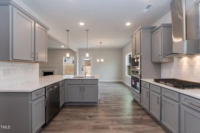a large kitchen with stainless steel appliances kitchen island granite countertop a stove and a sink