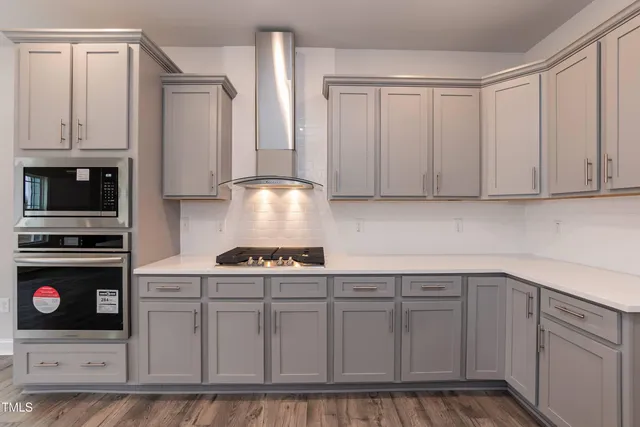 a kitchen with white cabinets and appliances