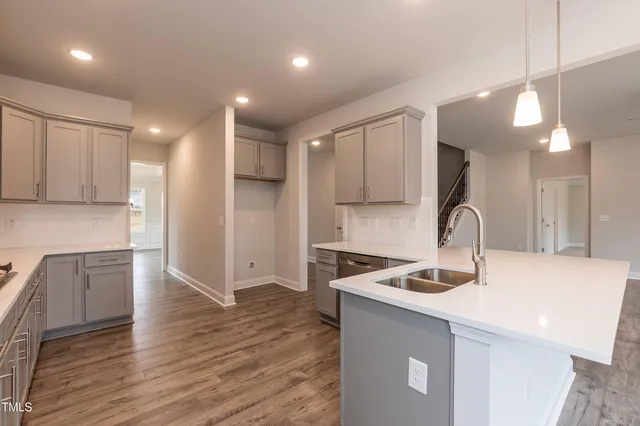 a kitchen with kitchen island sink refrigerator and cabinets