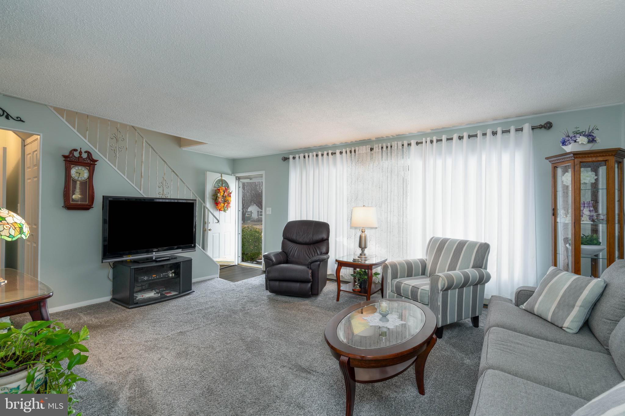 14 Tinder Road Levittown, PA 19056 - Photo 7 of 30 a living room with furniture a flat screen tv and a large window