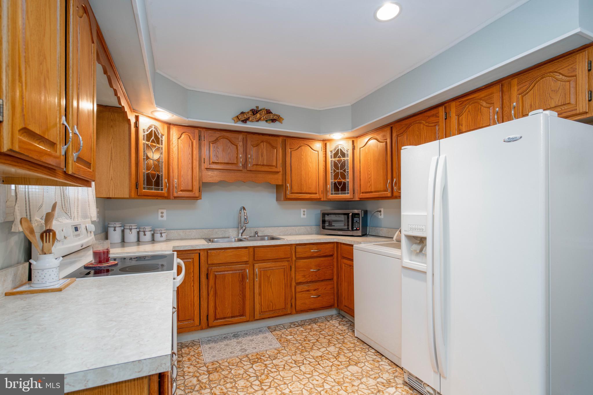 14 Tinder Road Levittown, PA 19056 - Photo 10 of 30 a kitchen with a sink a refrigerator and cabinets