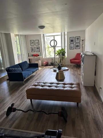 a living room with furniture window and wooden floor