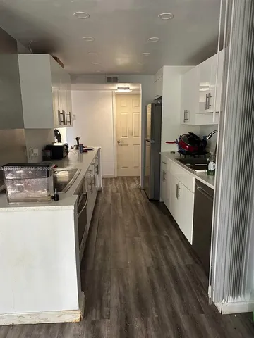 a kitchen with granite countertop a sink stove and refrigerator