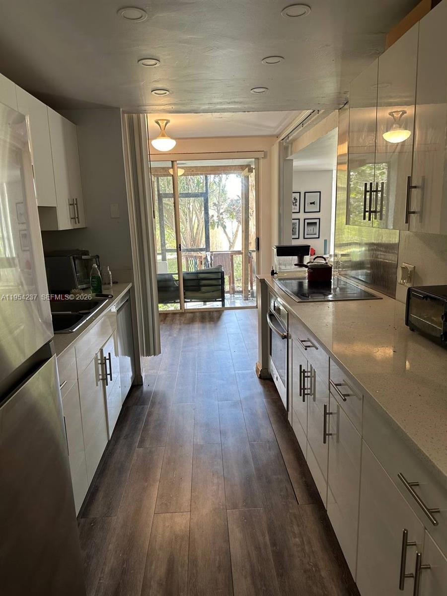 3720 Inverrary Drive, Unit 1L Lauderhill, FL 33319 - Photo 18 of 20 a kitchen with granite countertop a sink a counter top space and cabinets