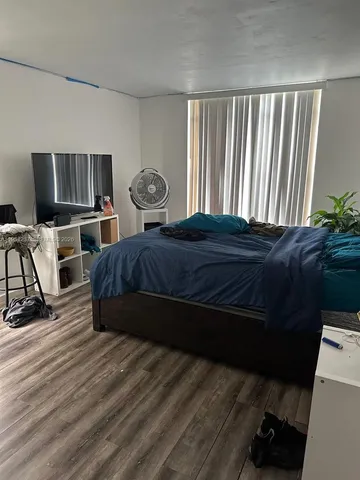a bedroom with a bed and flat screen tv