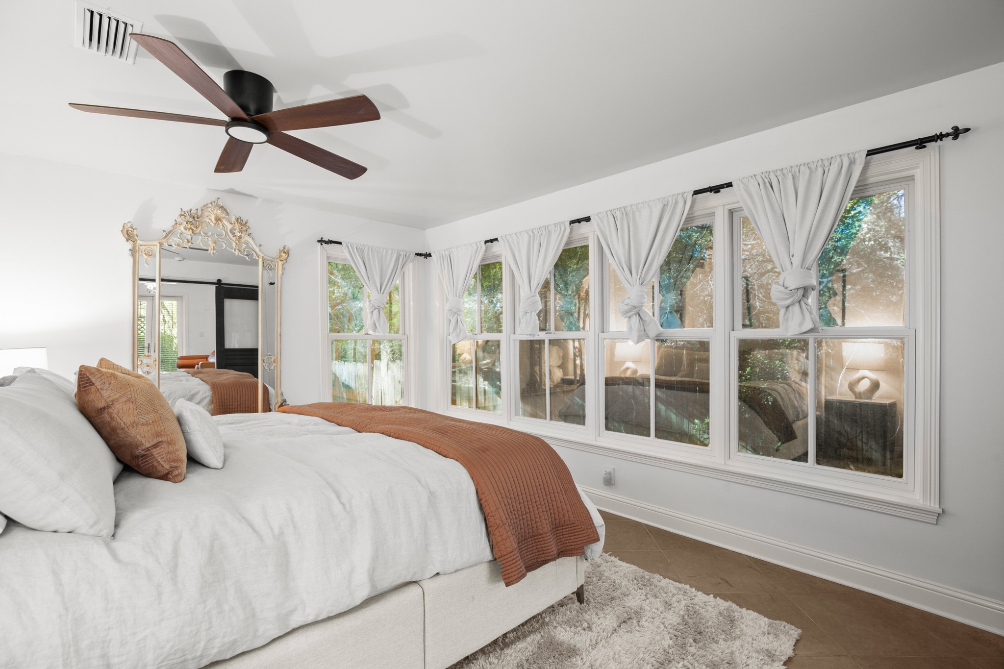1601 Whitney Way Austin, TX 78741 - Photo 21 of 30 Ample windows invite natural light into this serene bedroom, featuring a large ceiling fan for ultimate comfort.