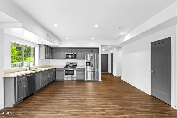 a large kitchen with stainless steel appliances granite countertop a large center island and a stove top oven