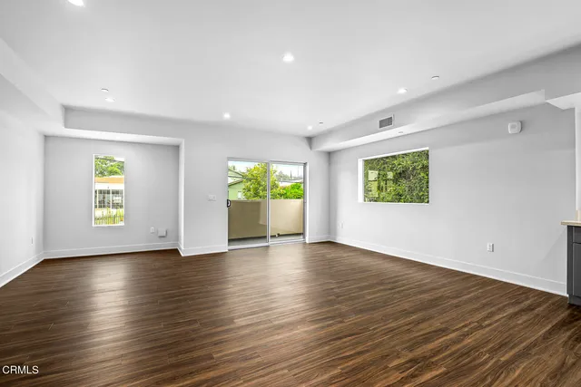 an empty room with window and wooden floor