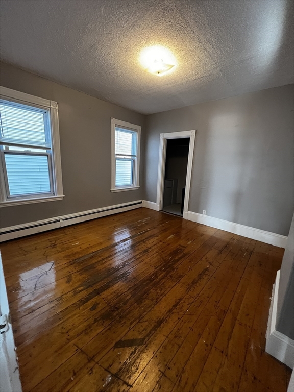 5 Sunset Street, Unit 2 Boston, MA 02120 - Photo 10 of 11 an empty room with wooden floor and windows
