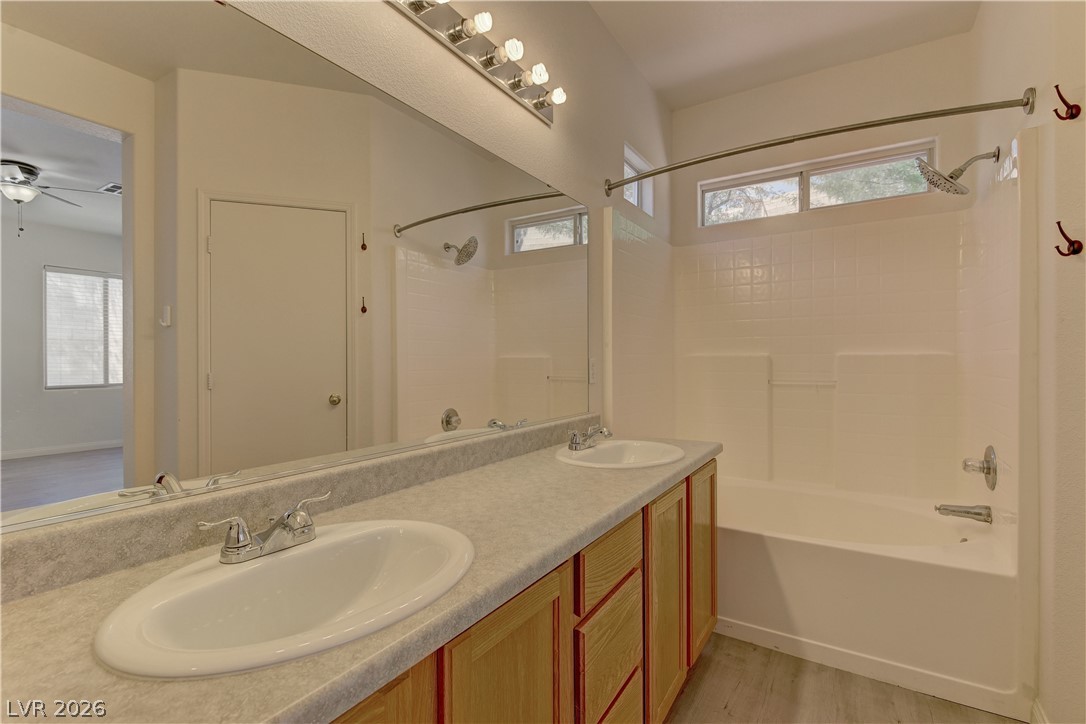 4613 Rising Cove Street Las Vegas, NV 89129 - Photo 11 of 20 This bathroom features a double vanity with ample counter space and a clean, functional tub-shower combination.