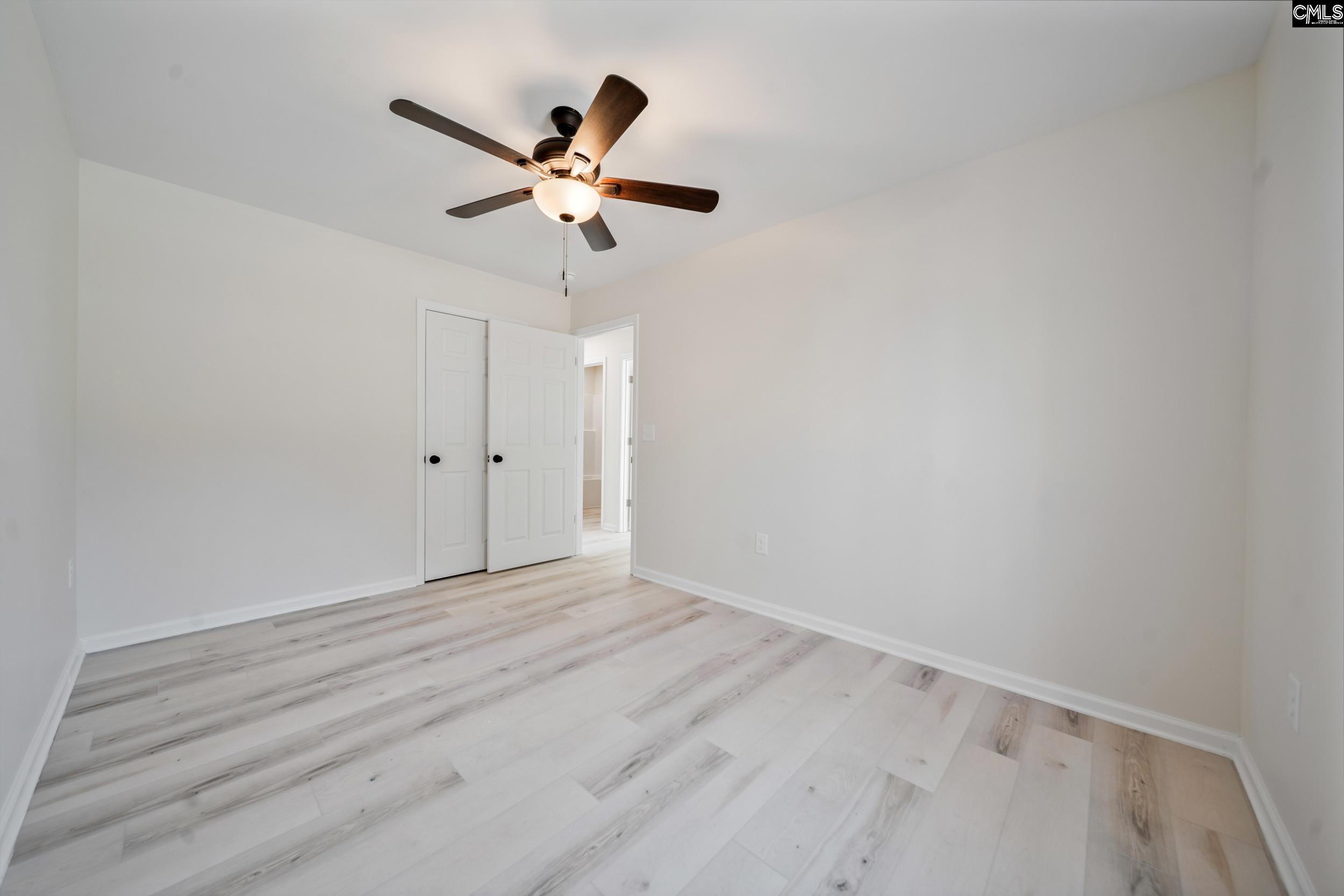 116 Sunny Acres Road Eastover, SC 29044 - Photo 19 of 40 a view of a room with wooden floor and a ceiling fan