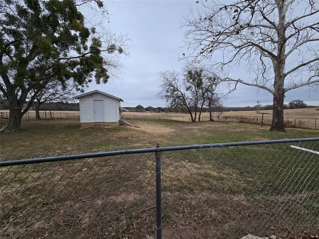 a view of a yard with wooden fence