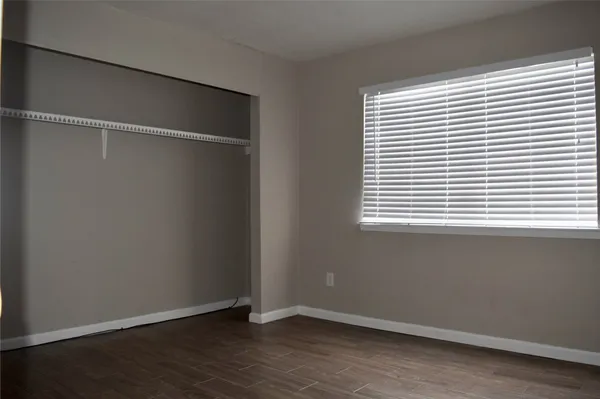 an empty room with wooden floor and a window