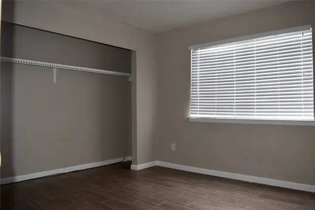 an empty room with wooden floor and a window