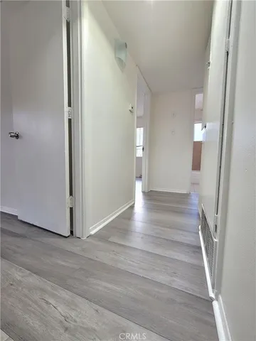 a view of a hallway with wooden floor