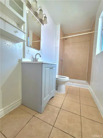 a bathroom with a sink a toilet a mirror and shower