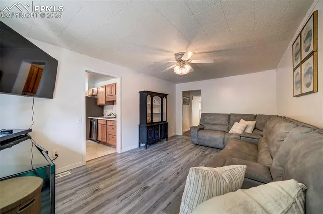 a living room with furniture and a wooden floor