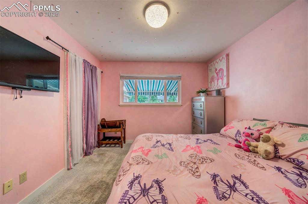 3710 Windflower Circle Colorado Springs, CO 80918 - Photo 24 of 32 a bedroom with a bed and a flat screen tv