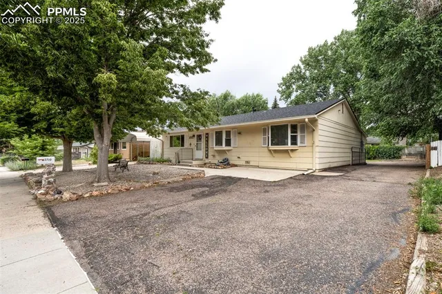 a view of a house with backyard and trees