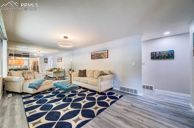 a living room with furniture and a wooden floor