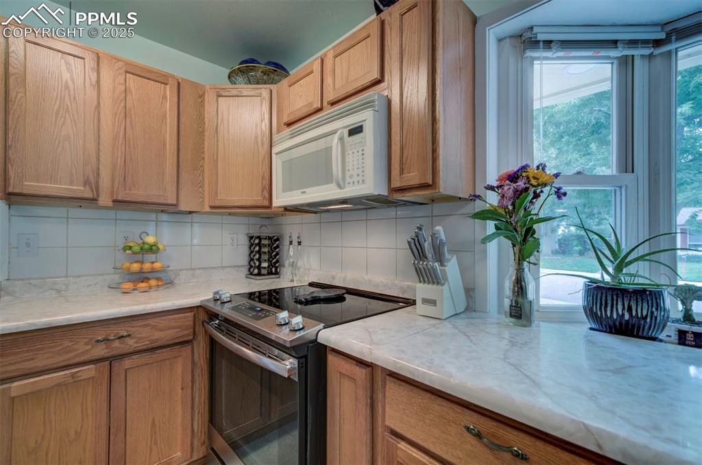 3710 Windflower Circle Colorado Springs, CO 80918 - Photo 10 of 32 a kitchen with stainless steel appliances granite countertop a sink a stove and a granite counter tops