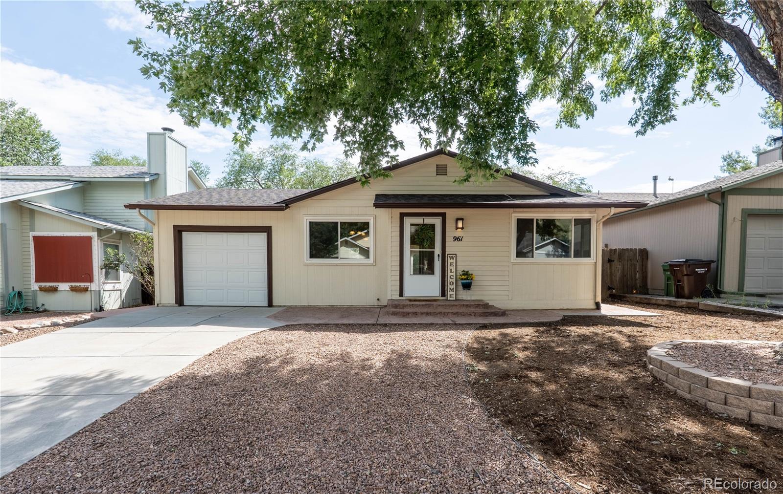 961 Columbine Avenue Colorado Springs, CO 80904 - Photo 1 of 47 a front view of a house with yard and trees in the background