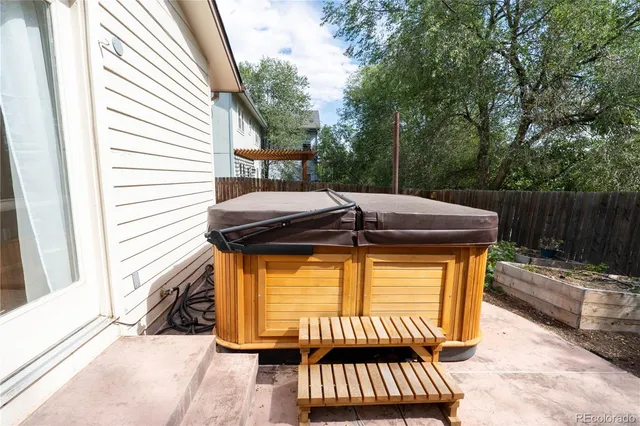 a view of a patio with a table and chairs and wooden fence