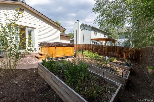 a view of a backyard with chairs potted plants and wooden fence