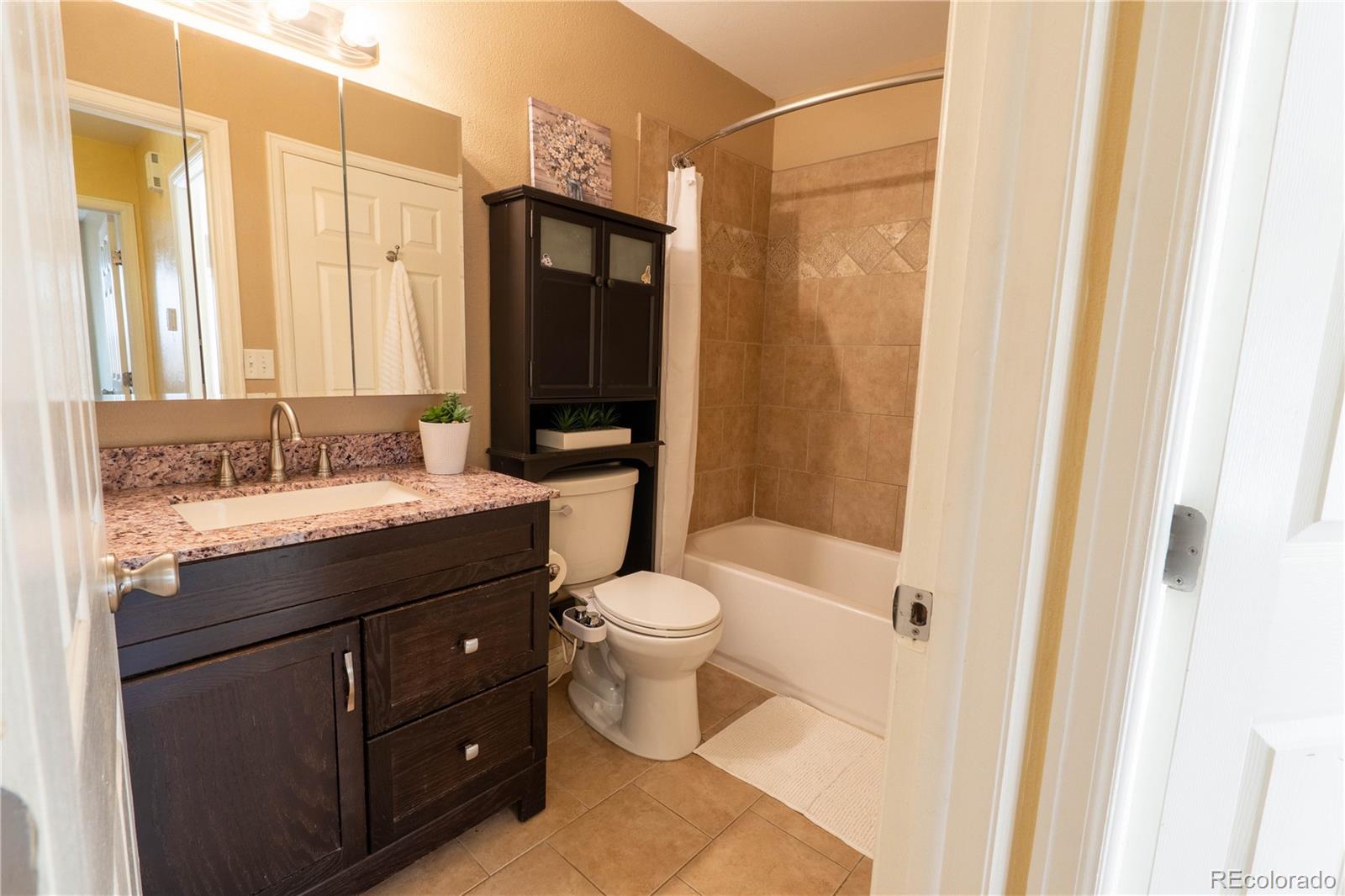 961 Columbine Avenue Colorado Springs, CO 80904 - Photo 35 of 47 a bathroom with a granite countertop sink toilet and shower