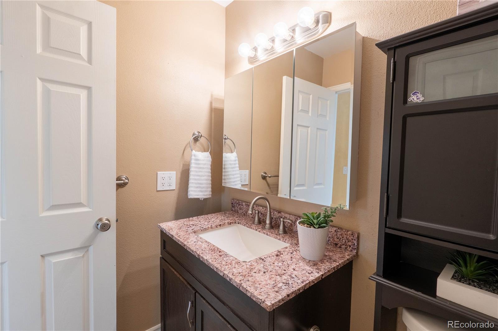 961 Columbine Avenue Colorado Springs, CO 80904 - Photo 37 of 47 a bathroom with a granite countertop sink and a mirror