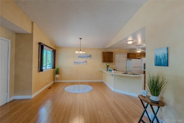 a kitchen with stainless steel appliances wooden floor and dining table