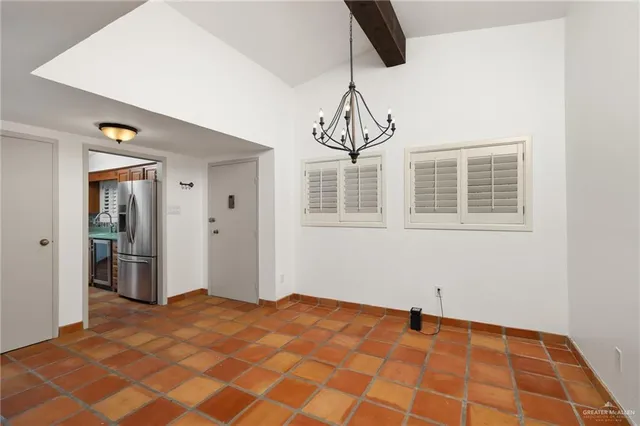 a view of a room with a chandelier and entryway