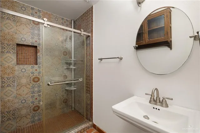 a bathroom with a sink a mirror and a shower